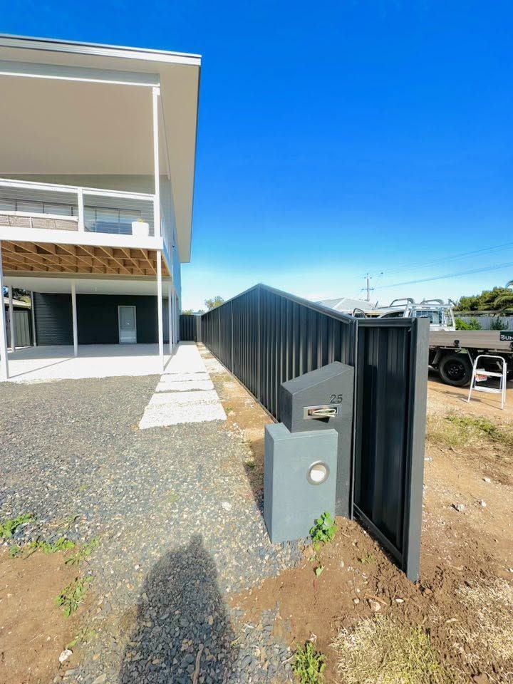 Black Colorbond front fence with rendered letterbox pillar