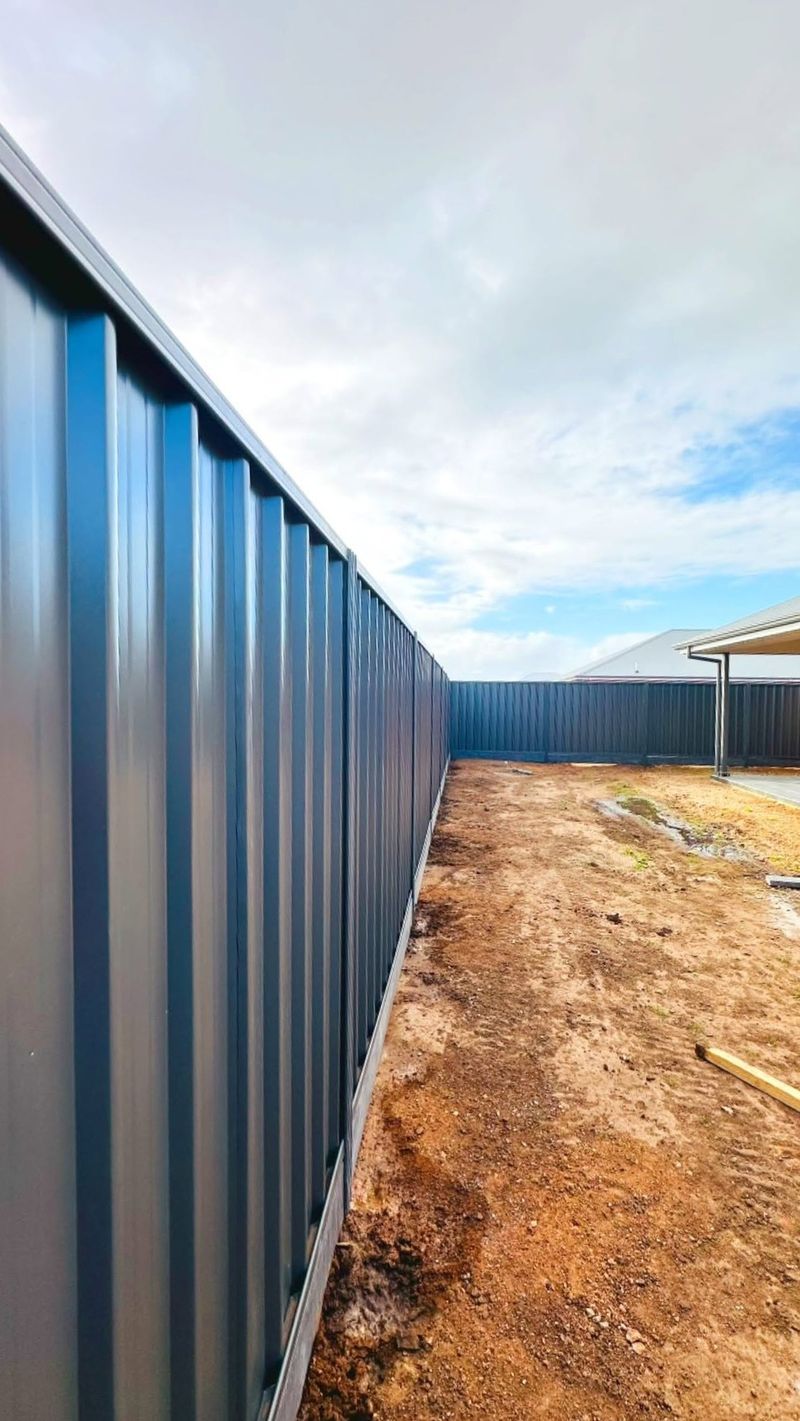Long run of dark grey Colorbond boundary fencing in Adelaide